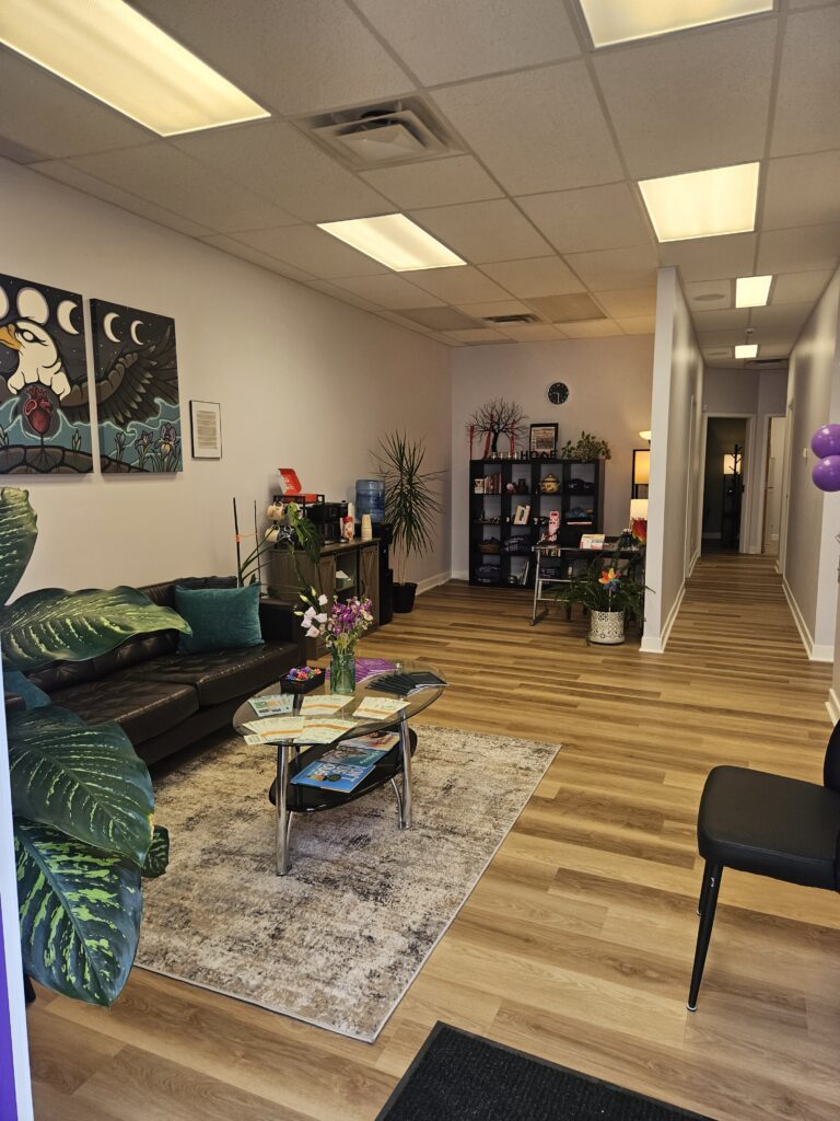A large open floorplan with couch, coffee table, desk, chairs, and bookshelves. 
